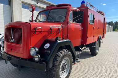 Historisches rotes Feuerwehrfahrzeug vor einer Fahrzeughalle. | © Förderverein Nürnberger Feuerwehr-Museum e.V. 