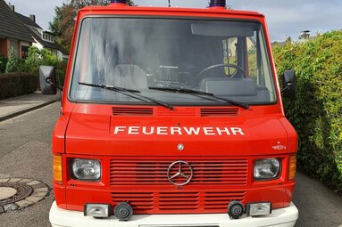 Frontansicht eines roten Feuerwehrfahrzeugs mit der Aufschrift „FEUERWEHR“ und Mercedes-Stern auf einer Straße.  | © Anke Lübke 