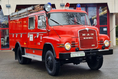 Rotes historisches Feuerwehrfahrzeug mit Blaulicht und Leiter auf dem Dach, abgestellt vor einem Feuerwehrgebäude. | © Freiwillige Feuerwehr Gomaringen 