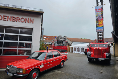 Mehrere historische Feuerwehrfahrzeuge, darunter Einsatzwagen, Drehleiter und Kommandofahrzeug, auf dem Gelände eines Feuerwehrhauses bei einer Jubiläumsveranstaltung ausgestellt. | © Feuerwehr Oldtimerfreunde Esslingen 